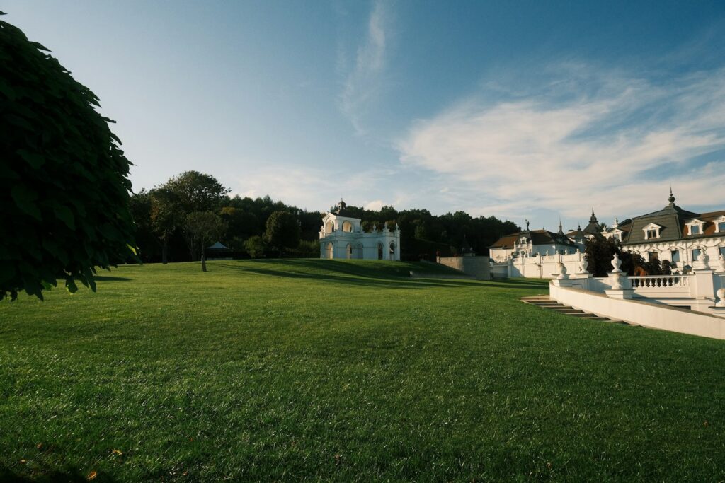 Manoir blanc entouré de pelouses et d'arbres, lieu de réception de mariage