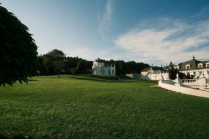 Manoir blanc entouré de pelouses et d'arbres, lieu de réception de mariage
