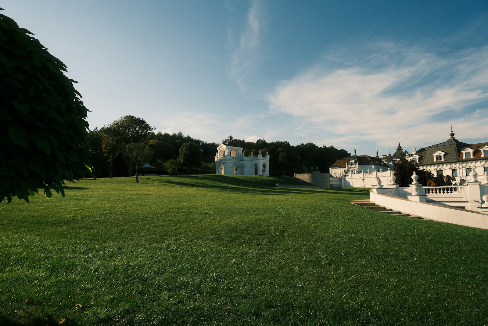 Manoir blanc entouré de pelouses et d'arbres, lieu de réception de mariage